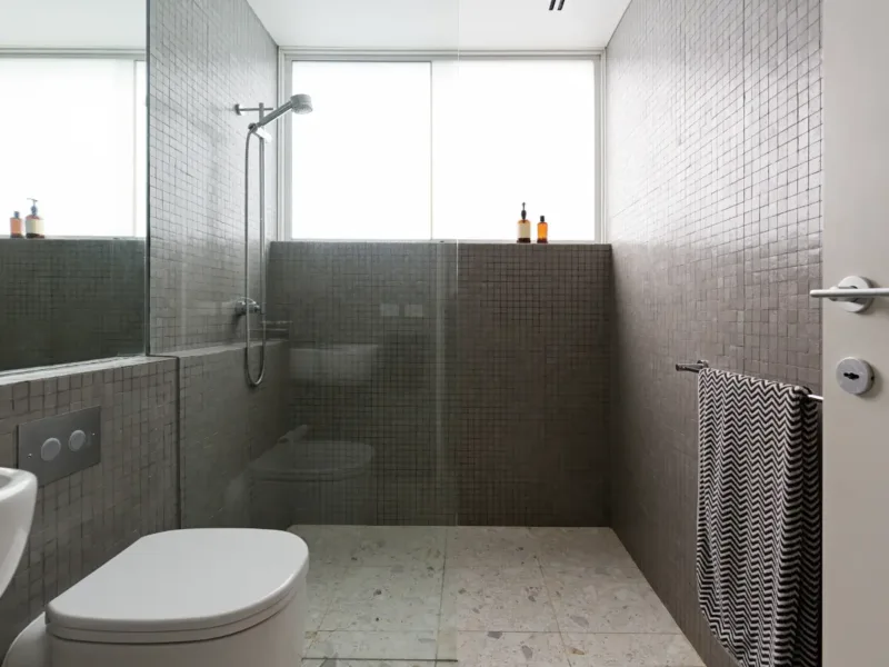 A fully tiled bathroom with a large walk-in shower and glass screen.
