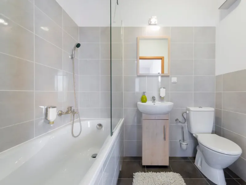 Bright tiled bathroom with a walk in shower and bath combo.